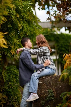 Young Cute Female Hugs Boyfriend. In Autumn Outdoor. Lovers Walking in Park. Attractive Funny Couple. Lovestory in Forest. Man and Woman. Cute Lovers in the Park. Family Concept. Happy Couple.