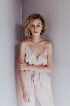 Portrait of a beautiful blonde woman in a pink jumpsuit