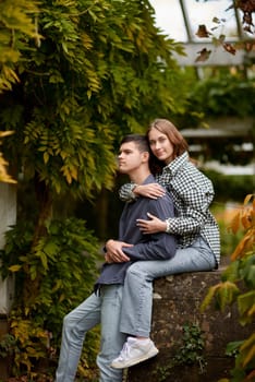 Young Cute Female Hugs Boyfriend. In Autumn Outdoor. Lovers Walking in Park. Attractive Funny Couple. Lovestory in Forest. Man and Woman. Cute Lovers in the Park. Family Concept. Happy Couple.