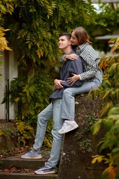 Young Cute Female Hugs Boyfriend. In Autumn Outdoor. Lovers Walking in Park. Attractive Funny Couple. Lovestory in Forest. Man and Woman. Cute Lovers in the Park. Family Concept. Happy Couple.