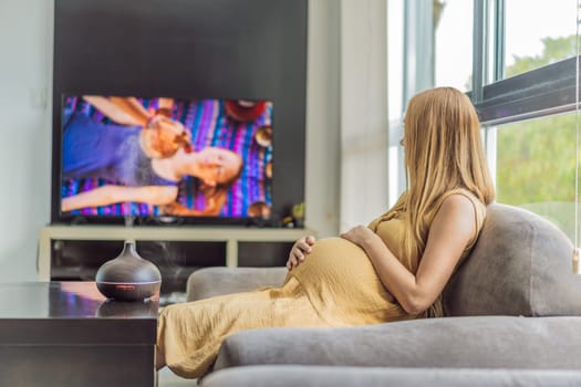 A blissful pregnant woman immerses in relaxation, savoring the soothing aroma from a diffuser while indulging in a calming TV video, embracing tranquility during her pregnant journey.