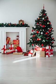 Christmas tree with gifts in the interior of the white room decor for the new year