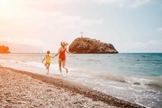 Happy loving family mother and daughter having fun together on the beach. Mum playing with her kid in holiday vacation next to the ocean - Family lifestyle and love concept.