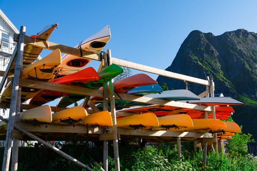 Vibrant and diverse kayaks arranged on racks at an outdoor adventure center, offering a captivating display of outdoor recreation and water sports options for enthusiasts on a sunny day.
