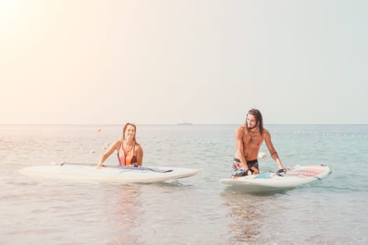 Woman man sea sup. Close up portrait of beautiful young caucasian woman with black hair and freckles looking at camera and smiling. Cute woman portrait in a pink bikini posing on sup board in the sea