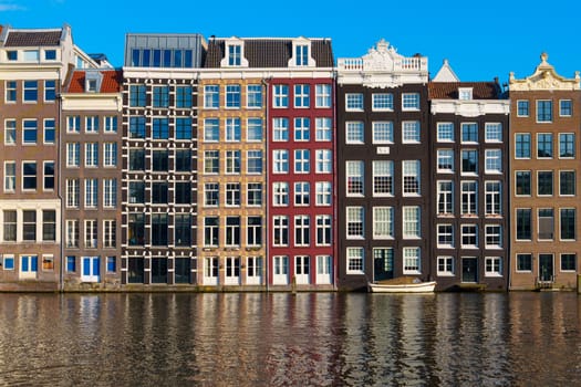 The image captures the historic charm of Amsterdam with colorful houses lining the charming canals, showcasing the city's picturesque beauty and architectural elegance.