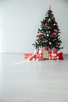 Christmas tree with gifts in the interior of the white room decor for the new year