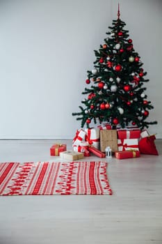 Christmas tree with gifts in the interior of the white room decor for the new year