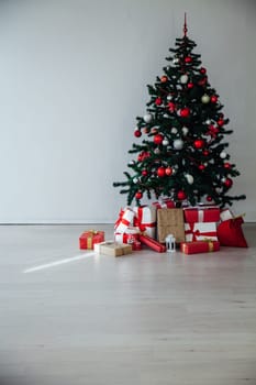 Christmas tree with gifts in the interior of the white room decor for the new year