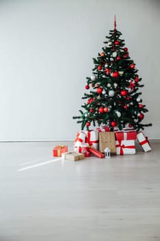 Christmas tree with gifts in the interior of the white room decor for the new year