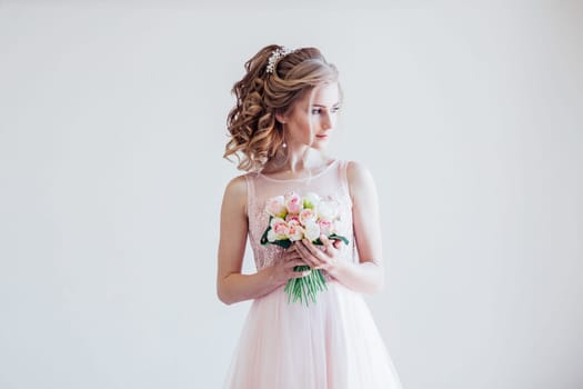 a beautiful bride in a pink wedding dress and bouquet of flowers
