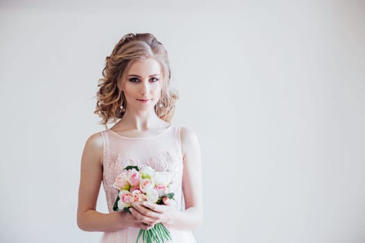 bride in wedding dress holding a bouquet of flowers in her hands