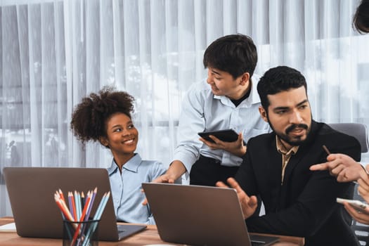 Happy diverse business people work together, discussing in corporate office. Professional and diversity teamwork discuss business plan on desk with laptop. Modern multicultural office worker. Concord