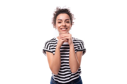 young slender caucasian woman with curly black hair is wearing a striped black and white t-shirt with a wide smile.