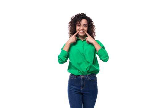 smiling young woman with black curly hair dressed in a green blouse.