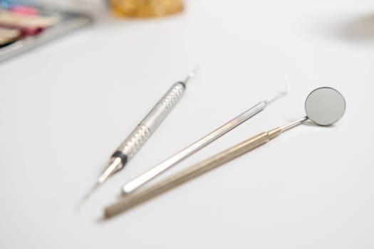 Dental mirror, explorer, hook, and dental tools on the table in dentists office