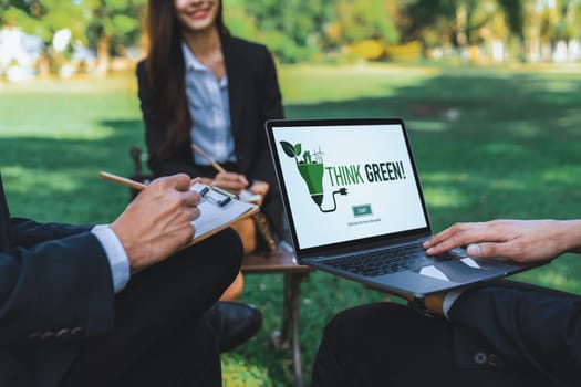 Group of asian business people planning on environmentally friendly development plan on laptop screen and sustainable technology project for greener future, outdoor eco office at natural park. Gyre