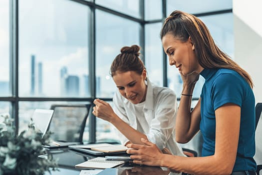 Portrait of two young beautiful caucasian businesswoman using phone while meeting to sharing searching brainstorming marketing idea. Group of businesswoman working together. Corporate. Tracery.