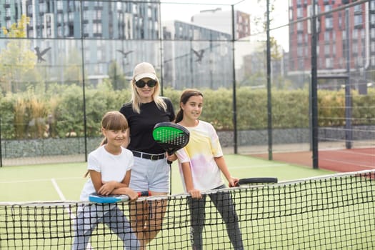 Active young woman practicing Padel Tennis with group of players in the tennis court outdoors. High quality photo