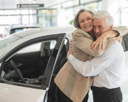 Mature Caucasian couple hugging. Elderly man and woman buying a new car