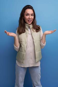 a young brunette woman in a shirt and a vest in an incomprehensible state is upset against the background with copy space.