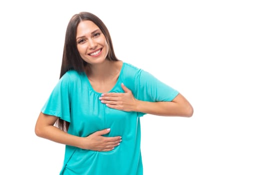 portrait of a pretty young caucasian brunette woman in a blue t-shirt on a white background with copy space.