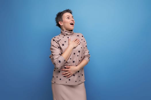 surprised 30 year old european woman with dyed gray hair in a skirt and blouse looks to the side and points with a finger.