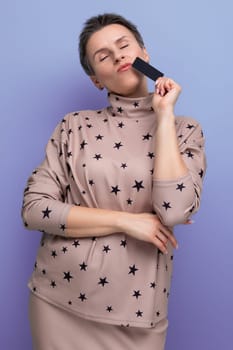 well-groomed young european lady with short streaked gray hair holding bank card mockup.