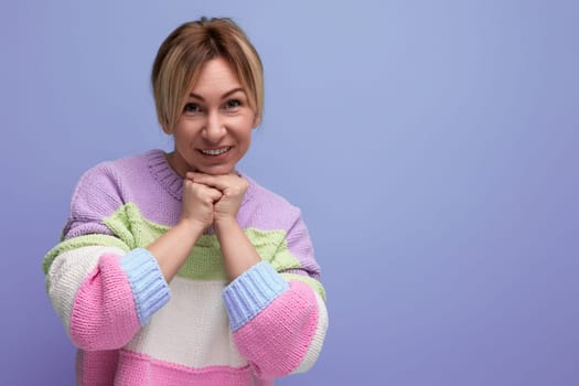 portrait of a cute blond young woman with a smile on her face on a purple background.