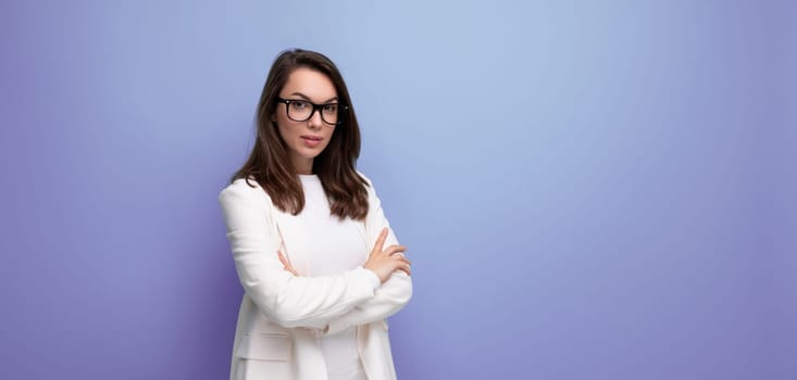 positive young business brunette woman in white office dress on blue studio background.