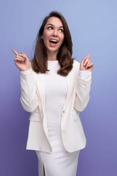 european brunette woman in white dress makes a grimace on studio background.