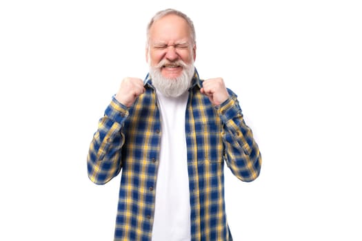 senior pensioner gray-haired man with a beard in a shirt dreams covering his eyes on a white background.