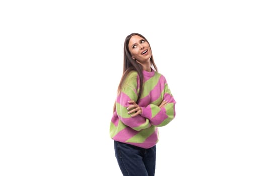 pretty positive cheerful young european brunette woman dressed in a striped pink-green pullover on a white background with copy space.