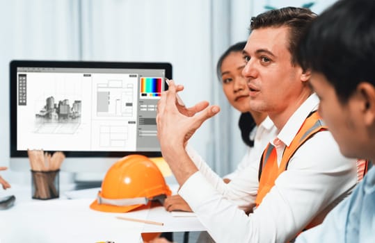 Diverse group of civil engineer and client working together on architectural project, reviewing construction plan and building blueprint at meeting table. Prudent