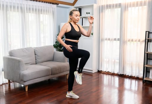 Athletic and sporty senior woman make running pose at home. Healthy fit body lifestyle as home workout exercise concept after retirement in full body shot. Clout