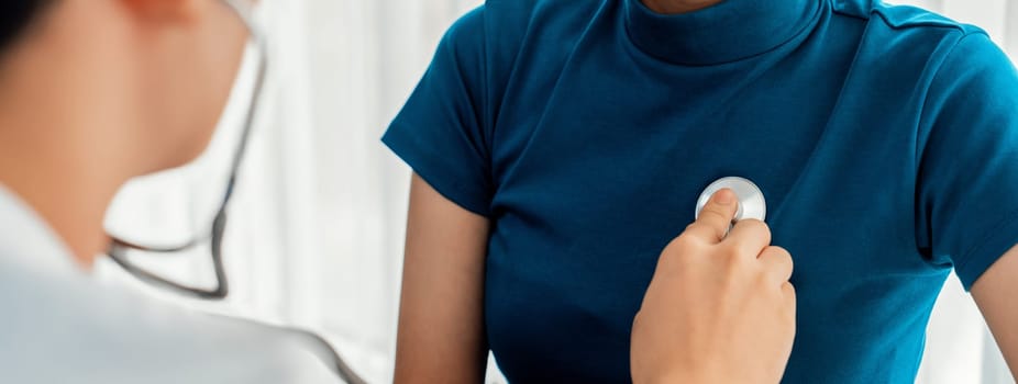 Patient attend doctor's appointment at clinic or hospital office. Doctor examining and diagnosis symptoms while checking the patient's pulse with stethoscope. Panorama Rigid