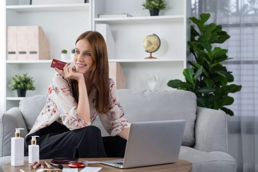 Young happy woman buy product by online shopping at home while ordering items from the internet with credit card online payment system protected by utmost cyber security from online store platform