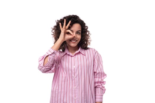 portrait of a charming 30 year old slender curly brunette model woman dressed in a shirt with a striped print.