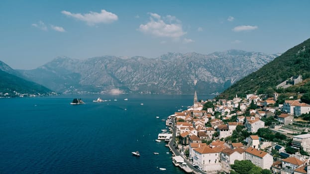 Boats sail along the Bay of Kotor past the coast of Perast. Montenegro. Drone. High quality photo