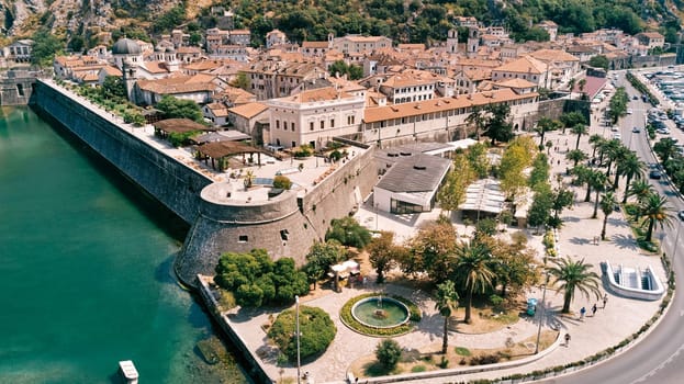 Park and a canal near the fortress walls of the ancient town. Kotor, Montenegro. Drone. High quality photo