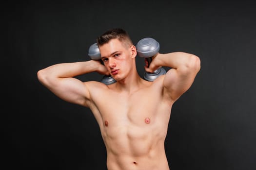 Man with pumped-up body with dumbbells in his hands white panties exercise
