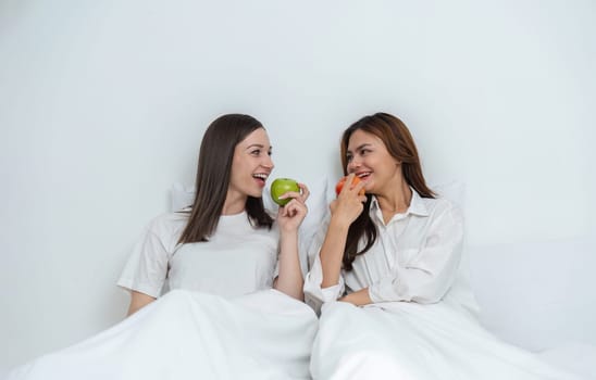 Young Asian lesbian couple sitting on bed during happy resting time Talk and relax in the bedroom..