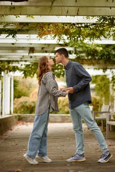 Young Cute Female Hugs Boyfriend. In Autumn Outdoor. Lovers Walking in Park. Attractive Funny Couple. Lovestory in Forest. Man and Woman. Cute Lovers in the Park. Family Concept. Happy Couple.