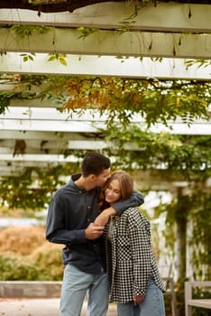 Young Cute Female Hugs Boyfriend. In Autumn Outdoor. Lovers Walking in Park. Attractive Funny Couple. Lovestory in Forest. Man and Woman. Cute Lovers in the Park. Family Concept. Happy Couple.