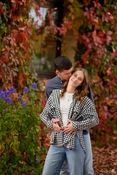 Young Cute Female Hugs Boyfriend. In Autumn Outdoor. Lovers Walking in Park. Attractive Funny Couple. Lovestory in Forest. Man and Woman. Cute Lovers in the Park. Family Concept. Happy Couple.