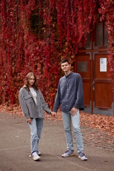 Young Cute Female Hugs Boyfriend. In Autumn Outdoor. Lovers Walking in Park. Attractive Funny Couple. Lovestory in Forest. Man and Woman. Cute Lovers in the Park. Family Concept. Happy Couple.