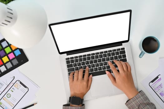 Female developer working with template layout framework for mobile phone application at desk.