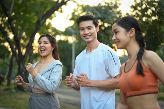 Group of sporty young people jogging together in the morning sunrise. Healthy Lifestyle concept.