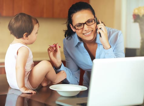 Businesswoman, phone call and baby with laptop for feeding in kitchen for remote work, productivity and job. Mother, freelancer and technology for communication while multitasking with childcare.