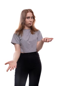European doubting teenager girl in a gray T-shirt with blond hair on a white studio background.